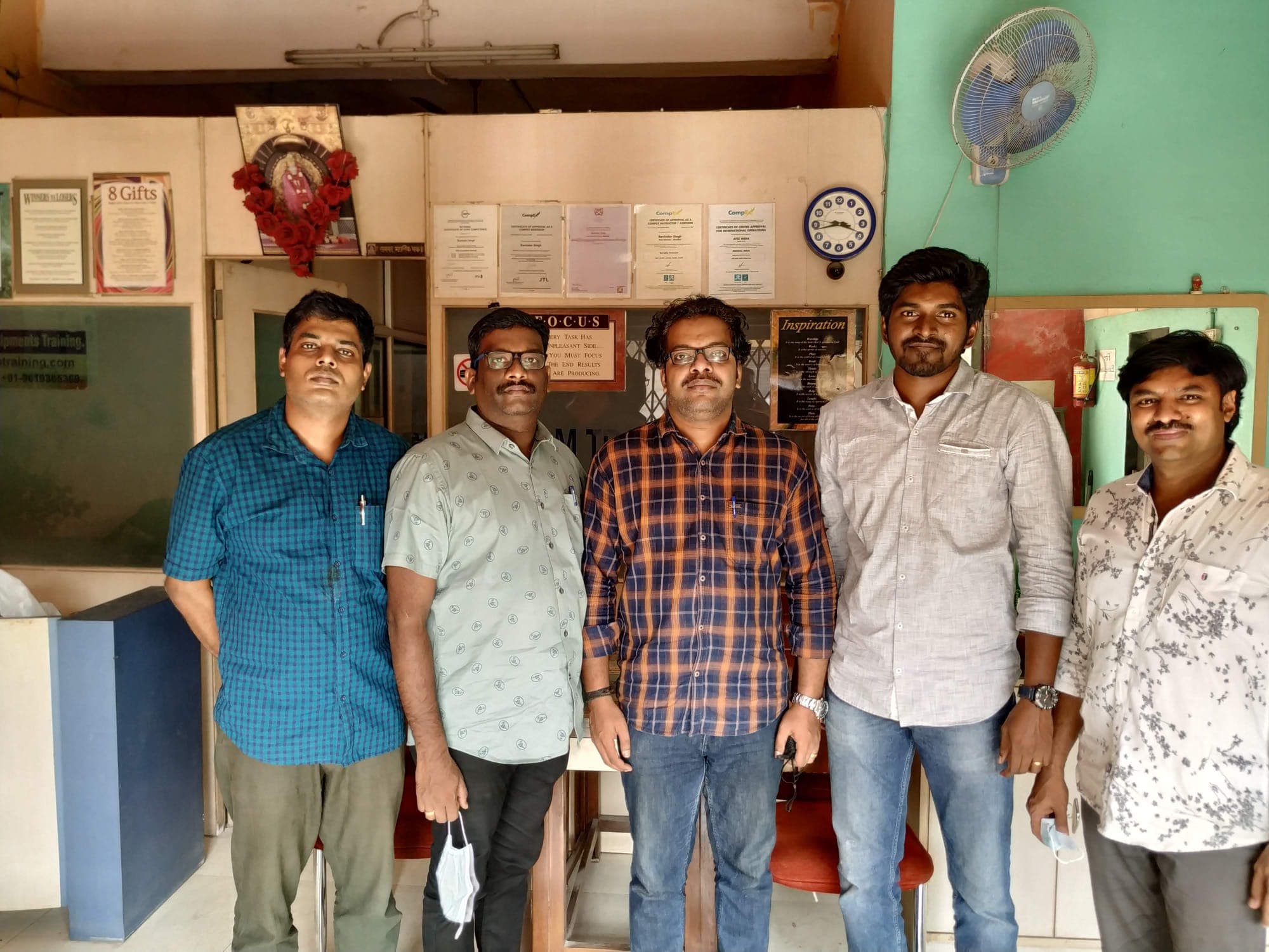 Five engineers with their trainer standing together in the centre's reception at the end of a course.